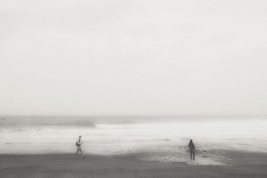 Imagen blanco y negro de playa con dos personas.